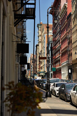 Naklejka na meble cars parked along cozy street with vintage buildings in downtown district of new york city