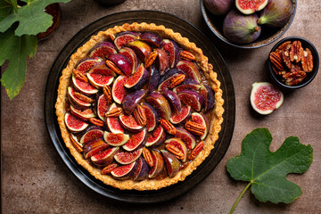 Sticker - Top view of California Fig and Bourbon Pecan Pie or tart, homemade pie crust with figs, brown sugar, butter, eggs and pecans filling, decorated with fresh figs and  toasted pecan. Brown table.