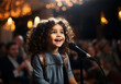 Cute little curly-haired girl sings songs into the microphone.