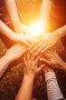 © Keitma - Lot of people hands united together in the air with sun light representing friendship and working together concept