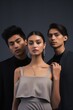 minimalist studio setting with a muted gray backdrop, three stylish young elegant individuals from diverse ethnicities stand closely, each exuding a distinct personality