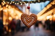 close-up of a traditional gingerbread heart hanging against the lively and blurred backdrop of a bustling Christmas market