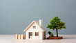 © Insight Lens - White Model house and green tree on wooden table with grey background, house marketing concept