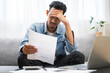 © Pormezz - Household financial economic concept, Stressed Young Asian adults are looking at credit card bills issued documents, and apartment loan mortgages and worrying about having no money to pay.