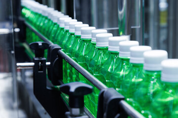 Wall Mural - transparent plastic bottles on the conveyor belt moving very fast into water filling machine in the drinking water factory. beverage industry.
