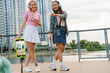 © Drobot Dean - Two cheerful girls making video with smartphone while standing on city waterfront