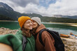 © olezzo - Young cheerful romantic lesbian couple traveling together in the mountains and taking selfies