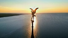 Aerial Drone View Of Statue Of Archangel Michael Atop The Spire Of Mont-Saint-Michel At Sunset In Normandy, France. Water Of The English Channel