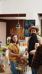 Canvas Print - Vertical video Vendor assisting client interrupted by his partner farmer arriving in eco friendly supermarket to deliver organic food order. Senior trader brings healthy vegetables to local