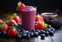 berry smoothie with scattered blueberries and strawberries around