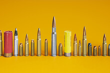 A Wide Array Of Ammunition Bullets And Shells, Neatly Lined Up In A Row.