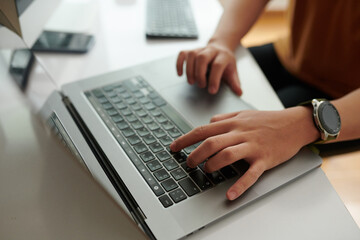 Wall Mural - Hands of developer working on laptop at his desk in home office