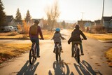 Fototapeta  - rear view of family riding bicycles in suburban neighborhood