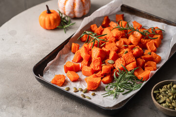 Poster - Oven baked pumpkin slices with rosemary and seeds on gray background, healthy vegetarian food