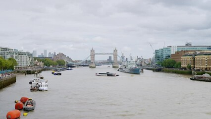 Wall Mural - View of the Thames river in London downtown, United Kingdom. Tower Bridge in the distance, moored HMS Belfast museum ship and other moored and floating boats