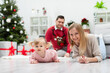 © fotodrobik - The happy family stays in a room near a decorated Christmas tree and presents
