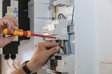 Circuit breaker installation. A technician plugs the cables into the circuit breaker.