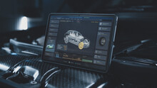 Tablet computer screen shows 3D animation of professional program for real-time car diagnostics and aerodynamics testing using 3D virtual electric vehicle model. Concept of car developing technology.