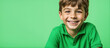 Excited smiling boy on solid green background