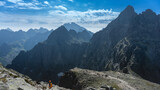 Fototapeta  - Tatry Wysokie, Rysy, zejście ze szczytu po stronie Słowackiej, w piękny letni dzień. Turystka z pomarańczowym plecakiem i kaskiem