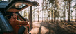 © Anna - A young man is sitting relaxed alone in the open trunk of a car in the woods by the lake at sunset.