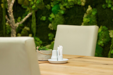 Detail of modern business hotel interior.  Table and two chairs against mossy wall in background, low depth of field. 