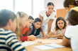 © JackF - Teacher and group of kids playing board game in school after lessons. Children having fun playing interesting game.