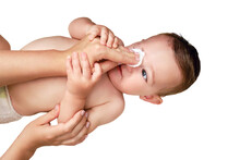 A Mother Washes Eyes Of A Happy Toddler Baby Boy With A Cotton Pad, Isolated On A White Background. Mom Cleanses The Skin On The Face Of A Smiling Child. Kid Age One Year