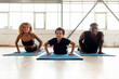 © Богдан Маліцький - African-American family in sportswear doing exercises on yoga mat, young parents doing sports with their son
