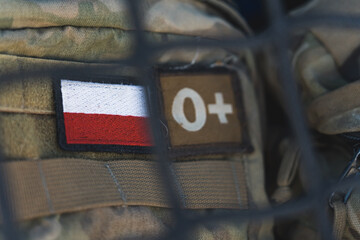 military patch with a polish white and red flag on. closeup shot of a soldiers backpack with their b