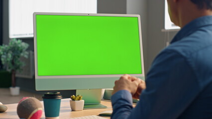 Wall Mural - manager talking mockup computer at video call. unknown man looking green screen