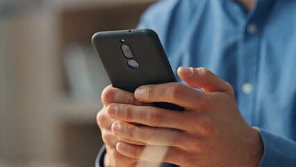 Wall Mural - man hands messaging mobile phone at room closeup. manager typing telephone alone