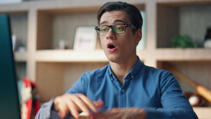 Wall Mural - Emotional businessman talking computer videocall office close up. Man gesturing