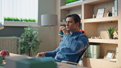 Wall Mural - Relaxed startuper drinking coffee working office closeup. Man staring computer
