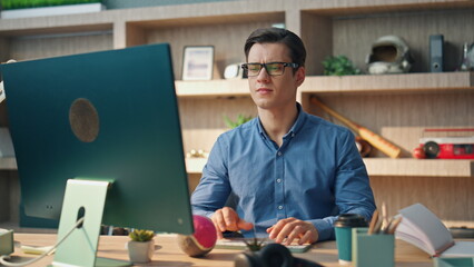 Wall Mural - Focused businessman working computer at office closeup. Tired man rubbing eyes