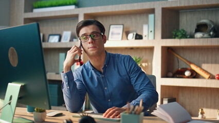 Wall Mural - Serious freelancer chatting smartphone office closeup. Talking man having call