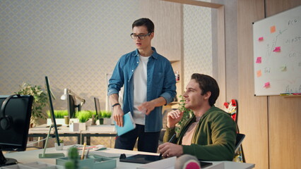 Wall Mural - Serious teammates working computer at office. Man staring monitor drawing tablet