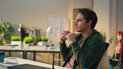 Wall Mural - Thoughtful startuper throwing ball thinking at room closeup. Man creating ideas