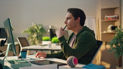 Wall Mural - Pensive freelancer watching screen at office. Graphic designer holding stylus