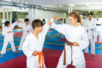 Wall Mural - Young children sparring in pairs to practice new moves in karate class