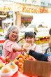 © CandyRetriever  - Happy Asian family grandmother and grandchild girl choosing and buying fresh fruit together at street market. Senior woman and little girl enjoy outdoor lifestyle travel in the city on summer vacation