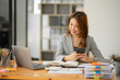 © Thitisak - Asian businesswoman working on documents at office