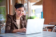 © maya1313 - Profile view of a young smiling woman using a laptop over white background