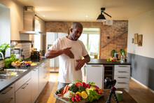 Middle aged African American male food nutritionist filming a video for his blog at home