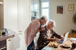 © Marko Geber - Senior Caucasian couple using the laptop together while having breakfast in the kitchen at home