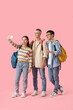 © Pixel-Shot - Happy students with backpacks taking selfie on pink background