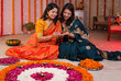© Knot9 Images - An Indian woman decorating her friend's hand with Henna/Mehendi  - Diwali celebrations  Indian culture  festive vibe. Two Indian sisters spending time together - festive season  sisters bonding  In...