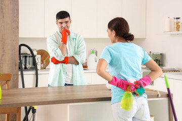 Canvas Print - Happy young couple cleaning in kitchen