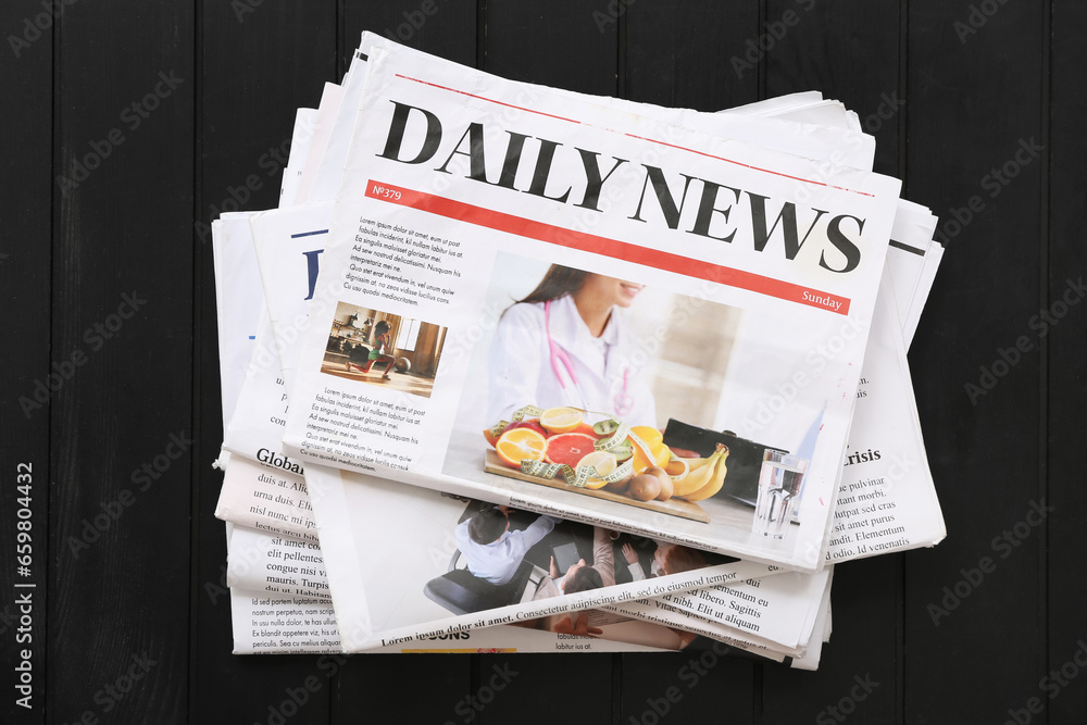 Morning newspapers on black wooden background