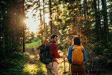 Two Hikers, Representing Diversity, Traverse A Rugged Terrain, Their Trusty Backpacks Packed With Essentials As They Navigate The Natural Wonders With Their Sturdy Walking Sticks